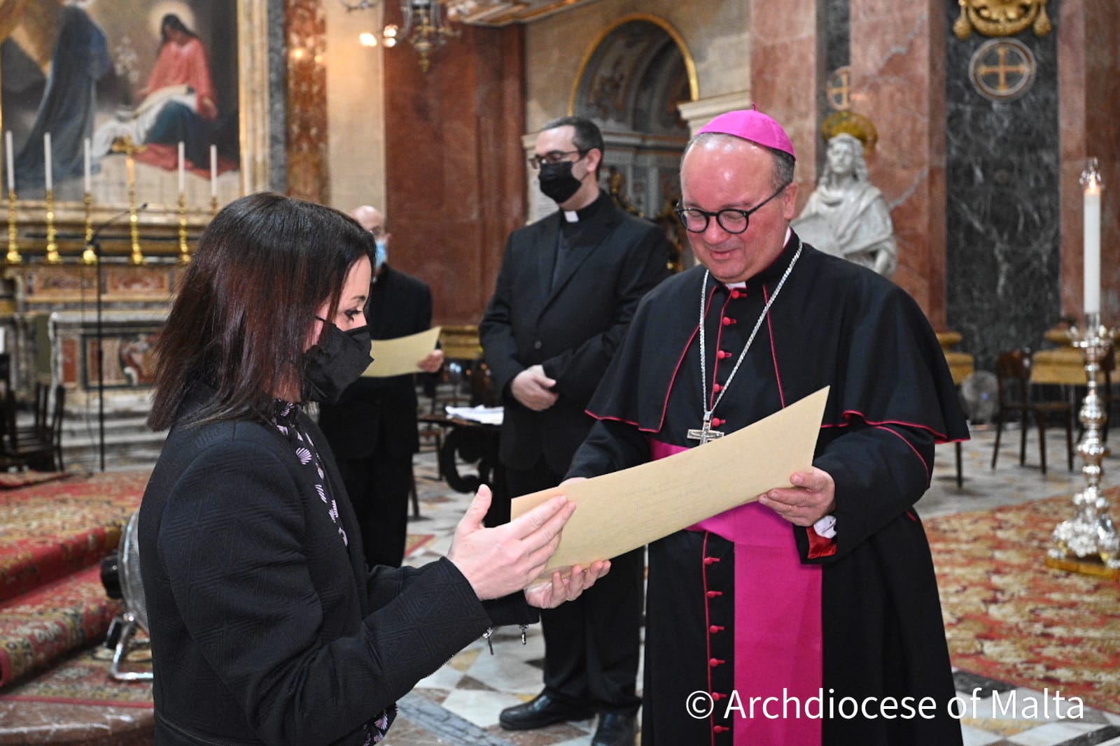 Archbishop Charles J Scicluna presenting a student with her certificate